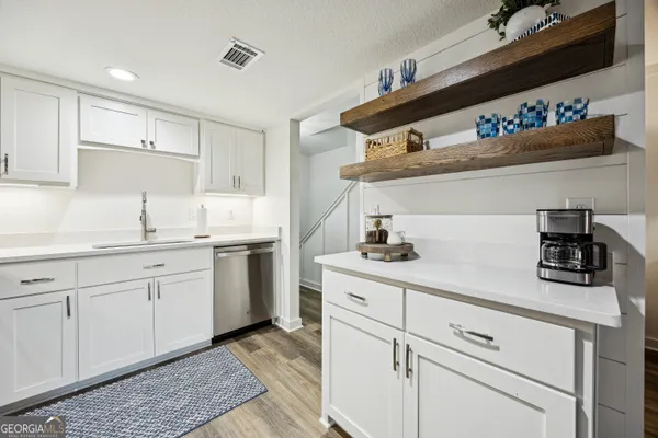 a kitchen with white cabinets stainless steel appliances and sink