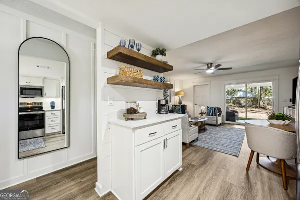 a large kitchen with cabinets wooden floor and stainless steel appliances