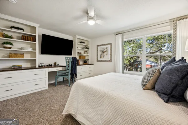 a bedroom with a large bed and a flat screen tv