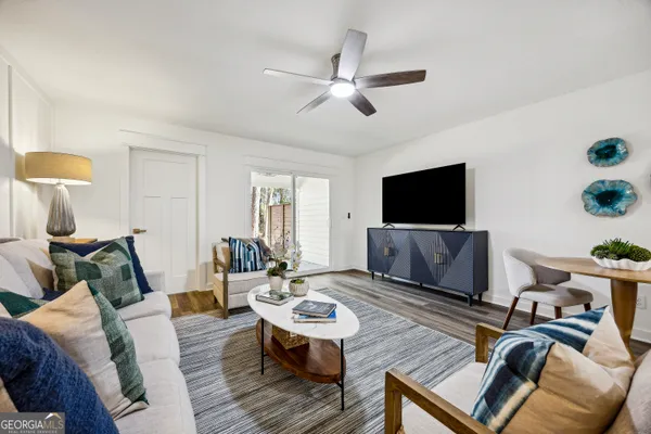a living room with furniture a flat screen tv and a window