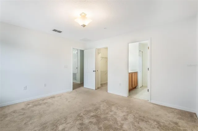 an empty room with closet and chandelier fan