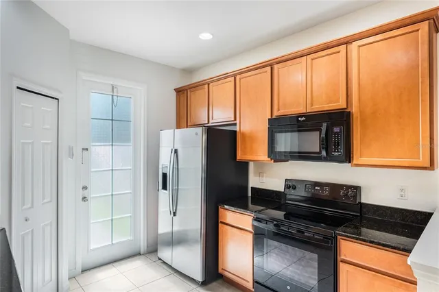 a kitchen with stainless steel appliances granite countertop a refrigerator and a stove top oven