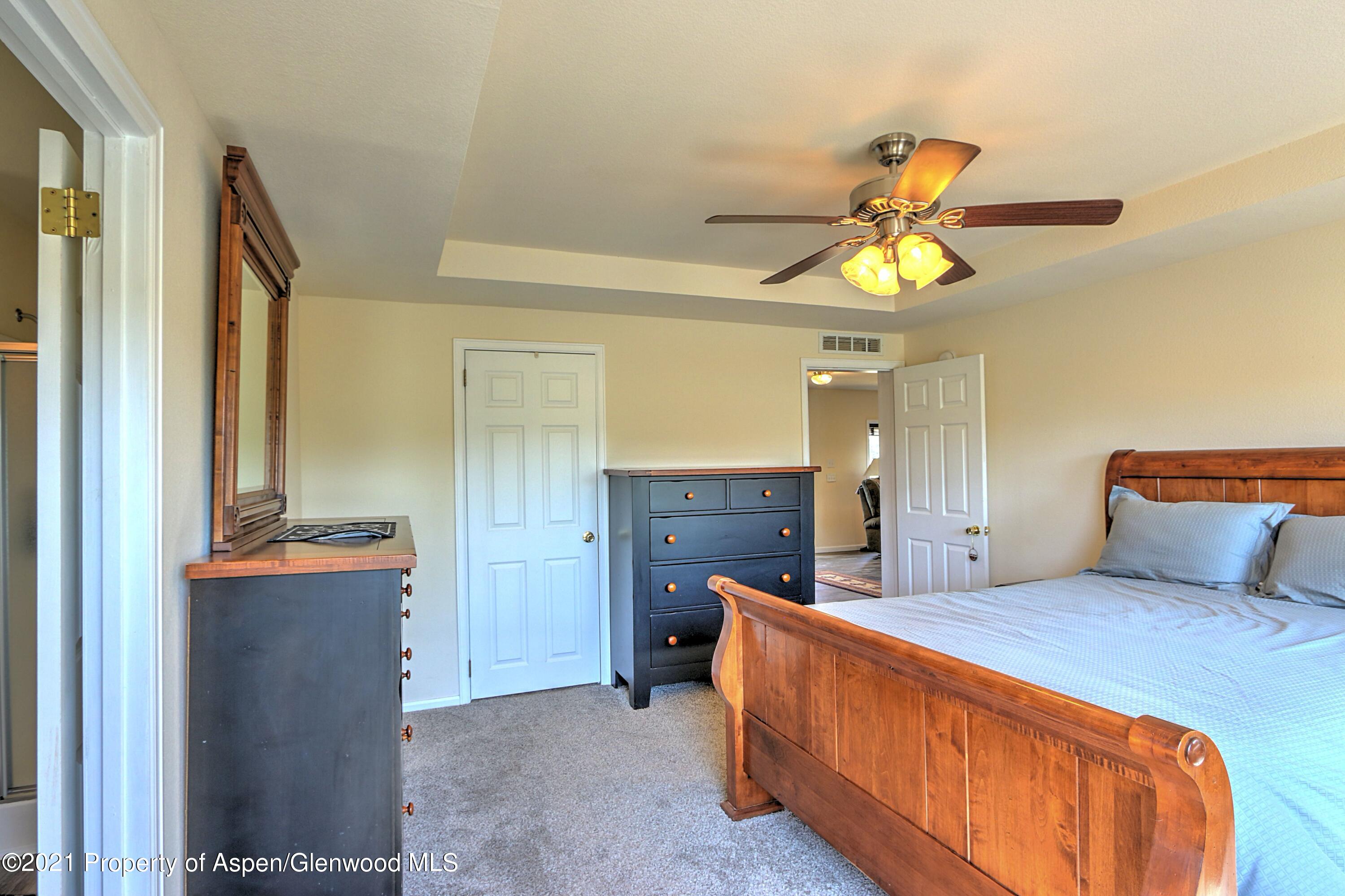 135 Swiss Lane Rifle, CO 81650 - Photo 13 of 46 a bedroom with a bed and a chandelier