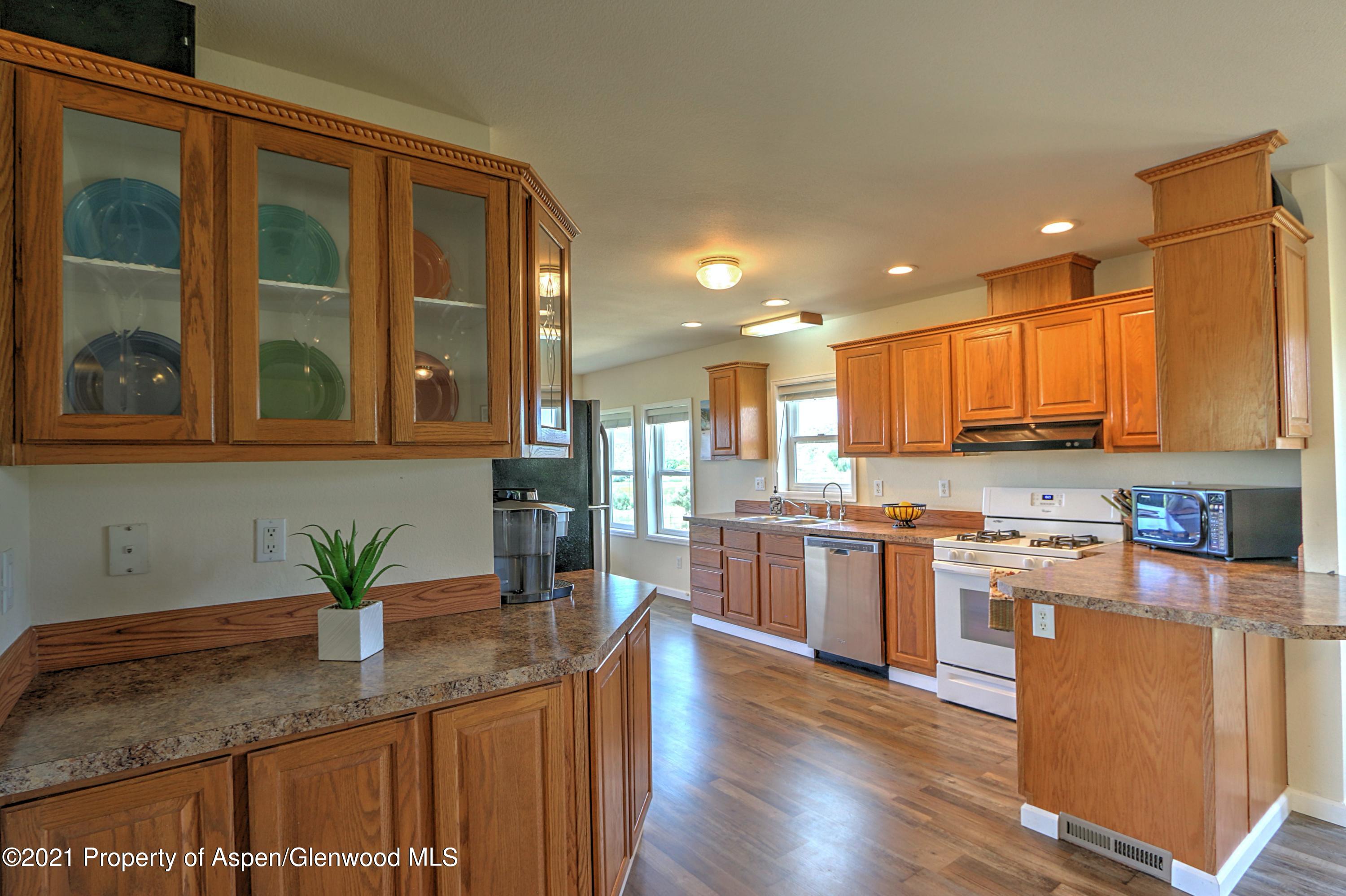135 Swiss Lane Rifle, CO 81650 - Photo 8 of 46 a kitchen with stainless steel appliances granite countertop a stove a sink and a refrigerator