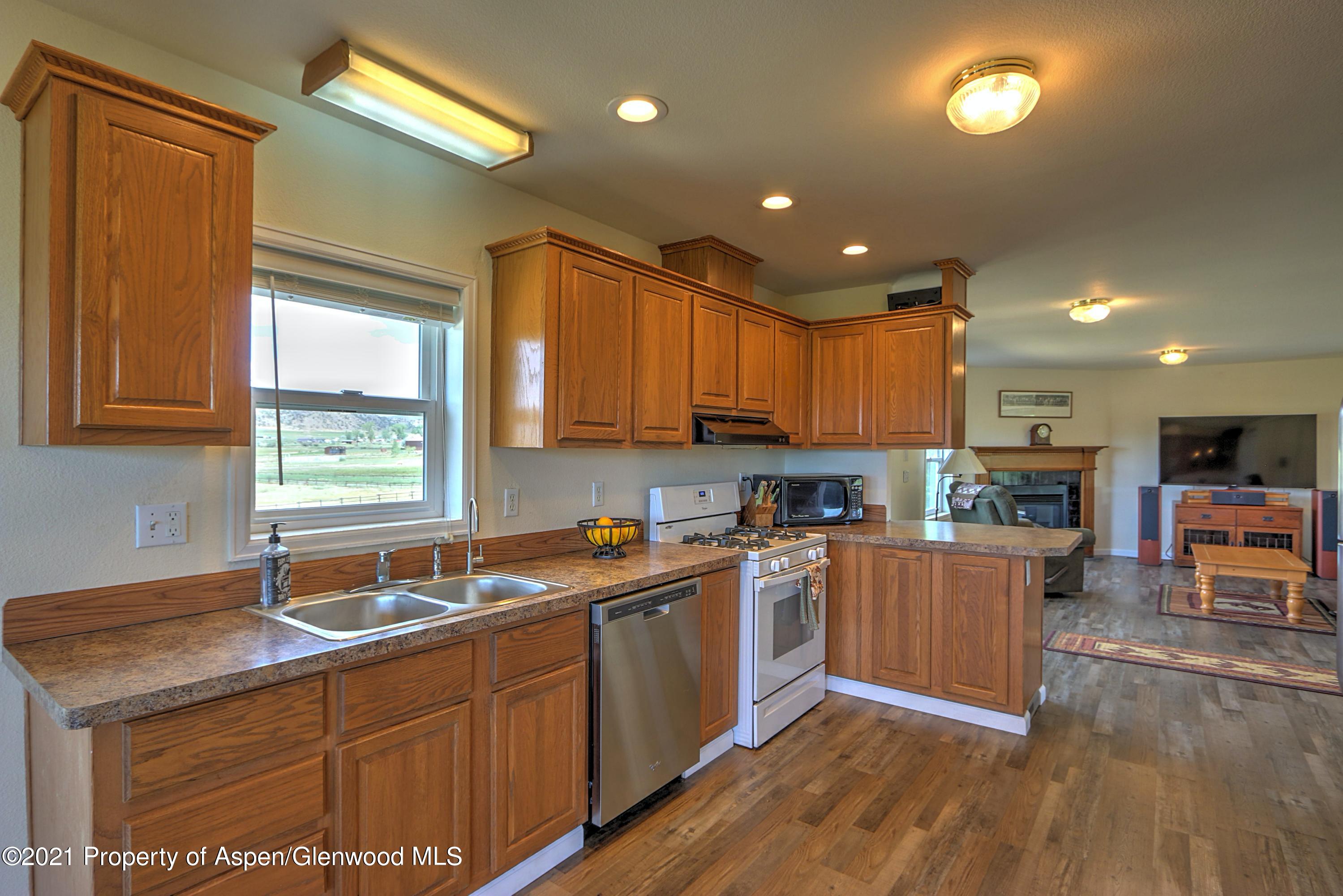 135 Swiss Lane Rifle, CO 81650 - Photo 9 of 46 a kitchen with stainless steel appliances granite countertop wooden cabinets a sink a stove a dining table and chairs