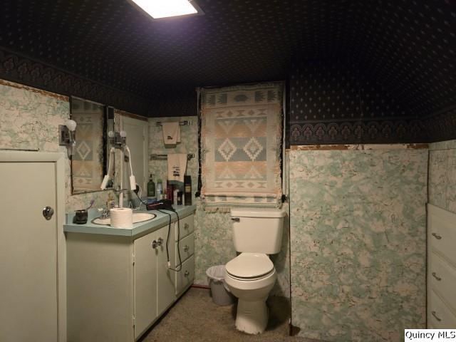 228 Wabash Avenue Carthage, IL 62321 - Photo 14 of 35 a bathroom with a granite countertop toilet sink and mirror