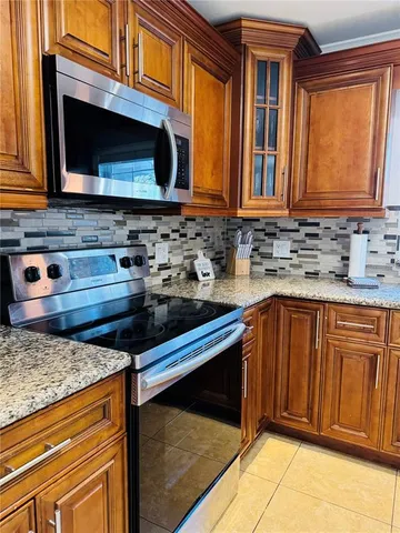 a kitchen with granite countertop stainless steel appliances a stove sink and microwave