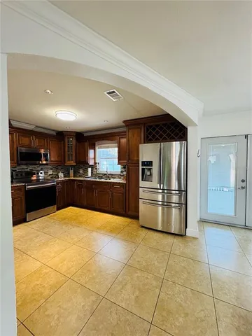 a large kitchen with a stove a refrigerator and a sink