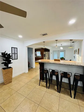 a dining hall with stainless steel appliances granite countertop a dining table and chairs