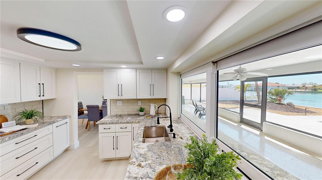 6380 3rd Palm Point St. Pete Beach, FL 33706 - Photo 11 of 48 a kitchen with stainless steel appliances granite countertop a stove a sink and a refrigerator
