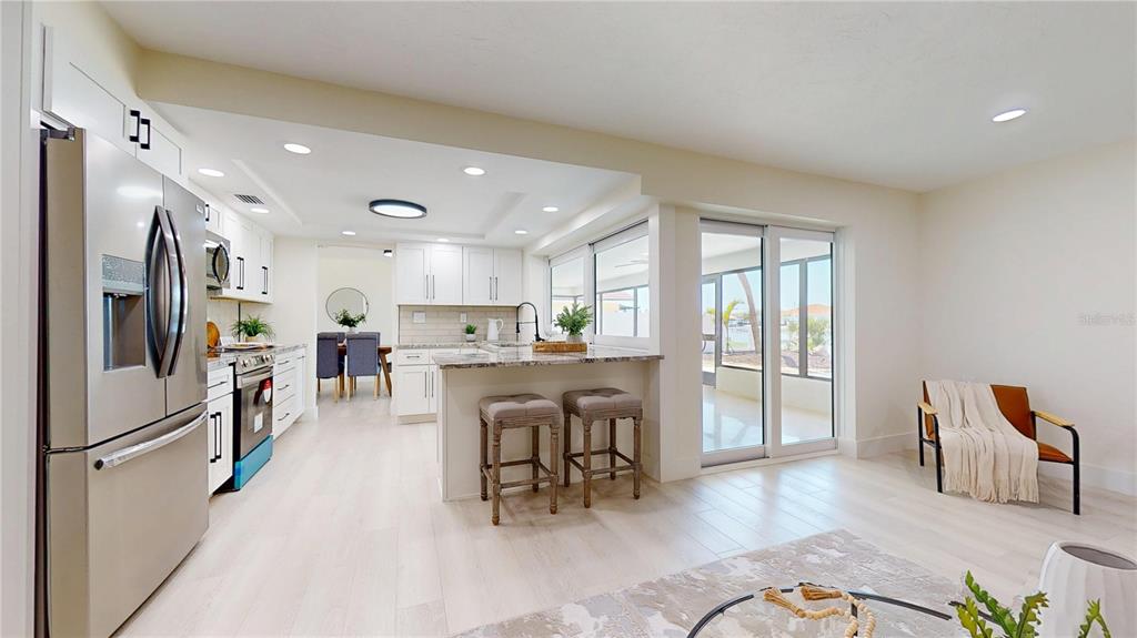 6380 3rd Palm Point St. Pete Beach, FL 33706 - Photo 18 of 48 a kitchen with stainless steel appliances granite countertop a refrigerator and a sink