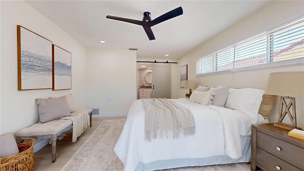 6380 3rd Palm Point St. Pete Beach, FL 33706 - Photo 31 of 48 a spacious bedroom with a bed a couch and a window