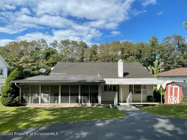 a front view of a house with a garden and trees
