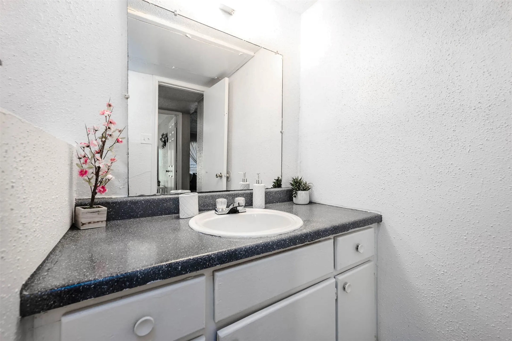 4300 Shaver Street, Unit 73 Houston, TX 77034 - Photo 6 of 8 a bathroom with a granite countertop sink and a mirror