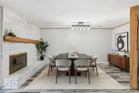 a view of a dining room with furniture wooden floor and a fireplace