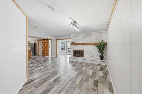 a view of empty room with wooden floor and fireplace