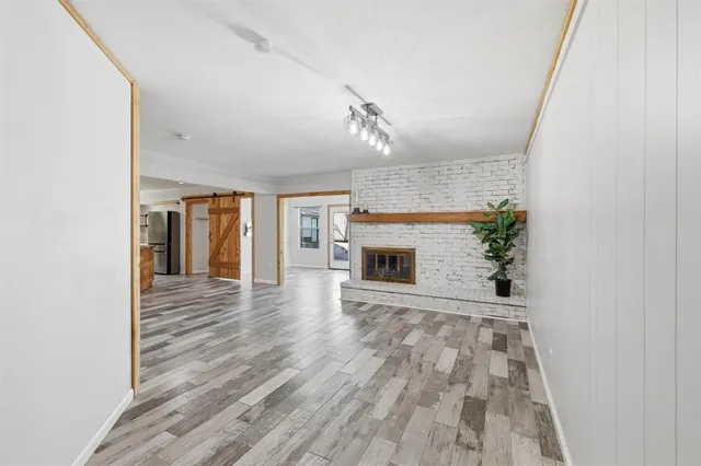 a view of empty room with wooden floor and fireplace