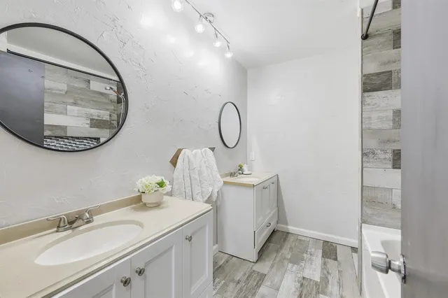 a bathroom with a granite countertop double vanity sink and a mirror
