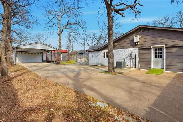 a view of a house with large trees and playing area