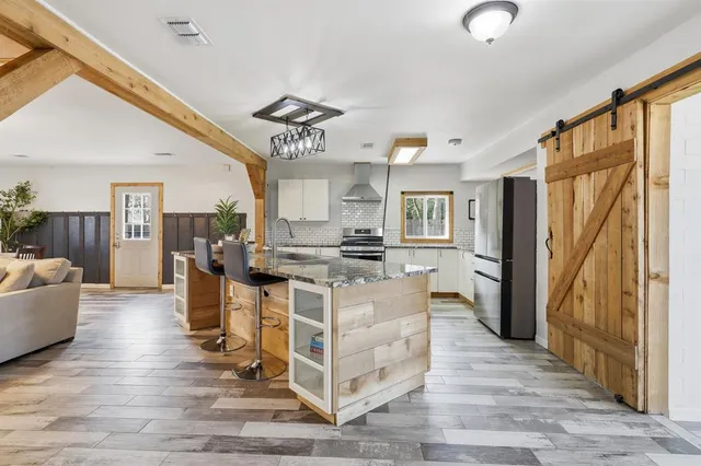 a living room with couches a dining table and chairs with wooden floor