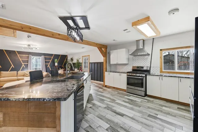 a kitchen with stainless steel appliances granite countertop a sink stove and refrigerator