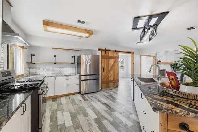 a kitchen with a refrigerator and a stove top oven
