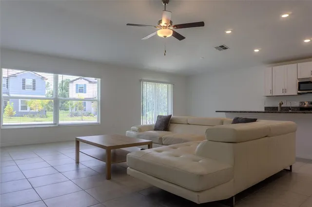 a living room with furniture and kitchen view