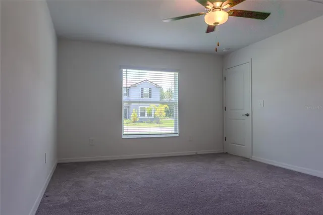 an empty room with a chandelier fan