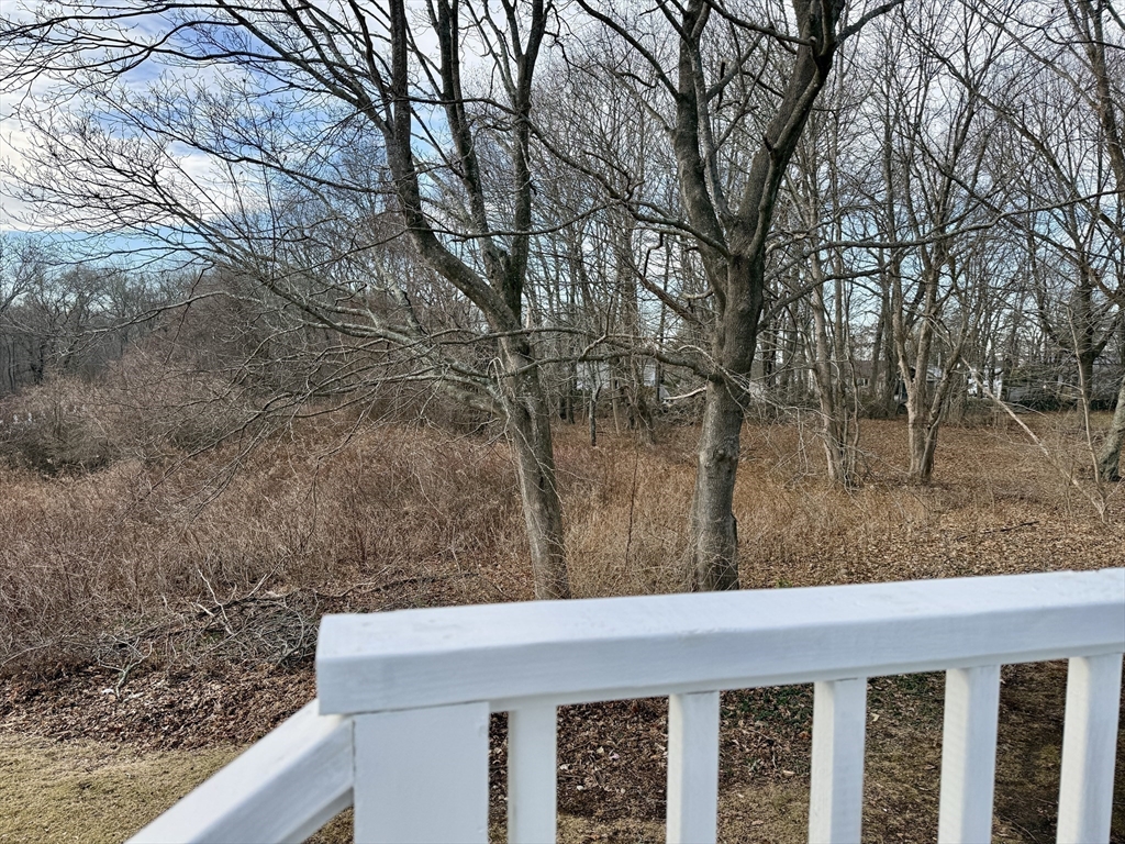 513 Slocum Road Dartmouth, MA 02747 - Photo 11 of 34 a view of a wooden floor and a trees in the background