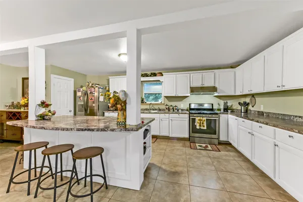 a kitchen with granite countertop white cabinets and white appliances