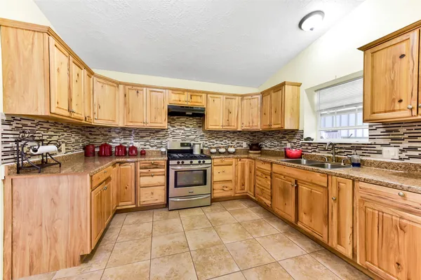a kitchen with stainless steel appliances granite countertop a refrigerator and a sink
