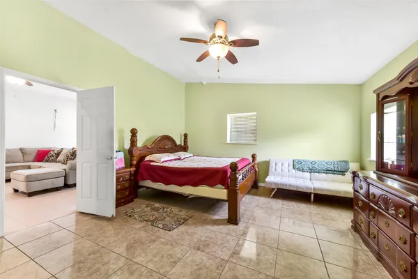 a bedroom with a bed and dresser with mirror