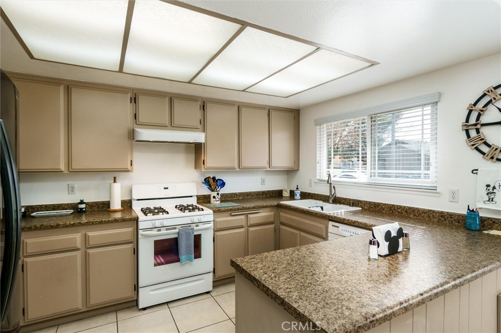 27062 Terrytown Road Menifee, CA 92586 - Photo 15 of 36 a kitchen with stainless steel appliances granite countertop a sink stove and cabinets
