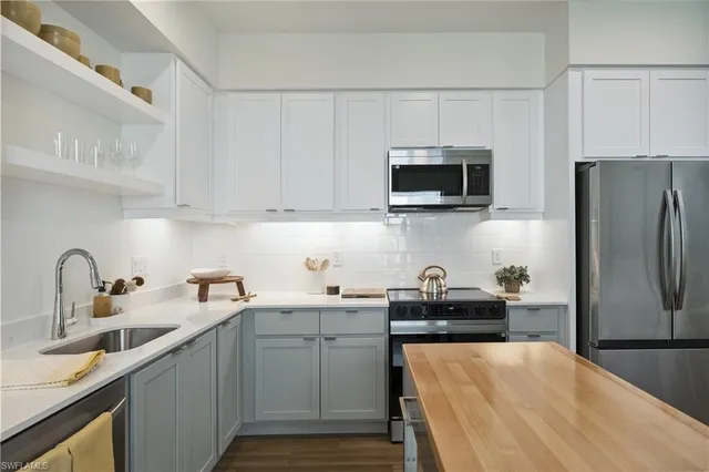 a kitchen with stainless steel appliances granite countertop a refrigerator sink and microwave