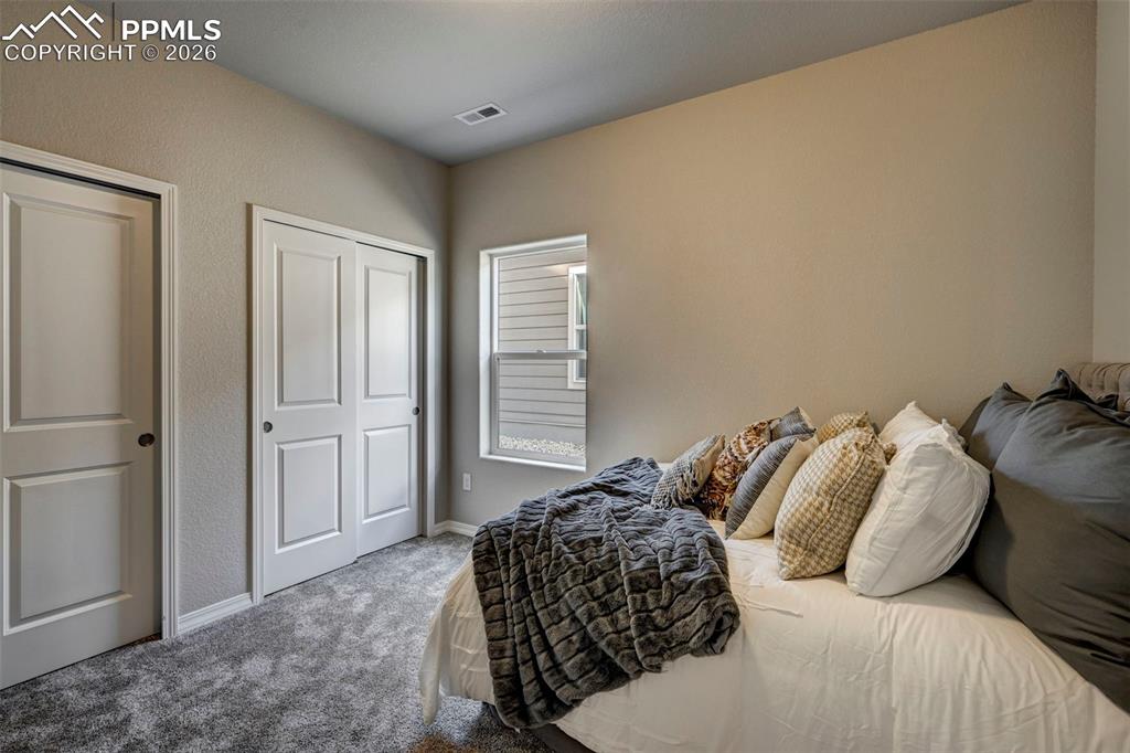 5167 Truscott Road Colorado Springs, CO 80925 - Photo 15 of 20 a bedroom with a bed and a window