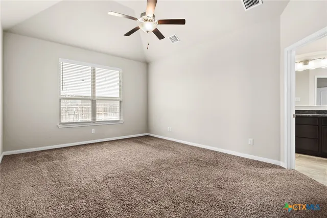 an empty room with windows and fan