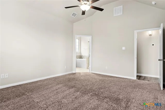 an empty room with a ceiling fan and a window