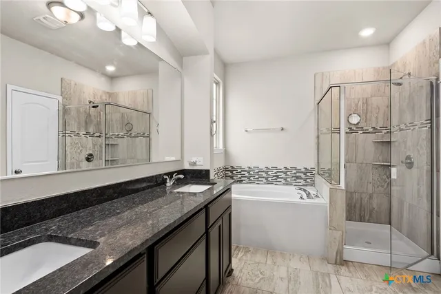 a bathroom with a granite countertop sink a toilet a mirror and shower