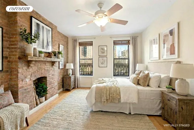 a bedroom with a bed couches and a fireplace