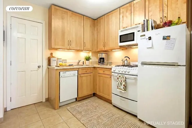 a bedroom with a bed a fireplace with a couch and chandelier