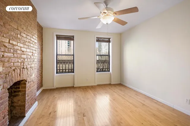 a view of an empty room with a fireplace and a window