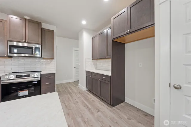 a kitchen with stainless steel appliances granite countertop a sink stove and microwave