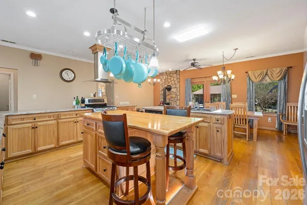 a kitchen with stainless steel appliances granite countertop a kitchen island a stove a table and chairs in it