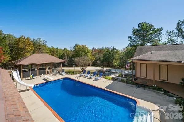a view of a chairs and table on the wooden deck with a backyard