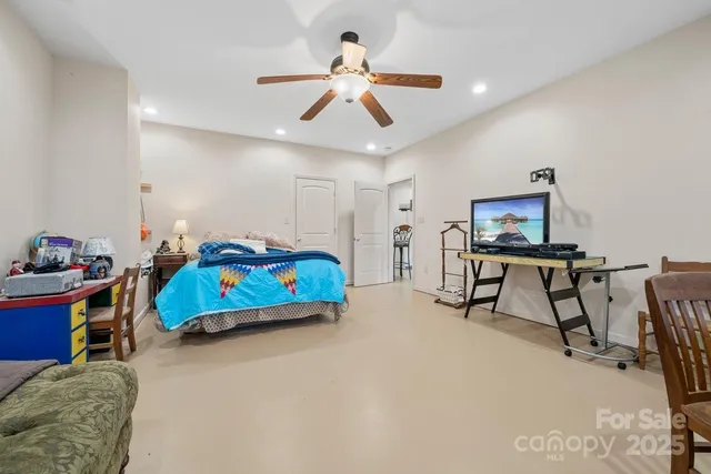 a bedroom with furniture and a chandelier fan