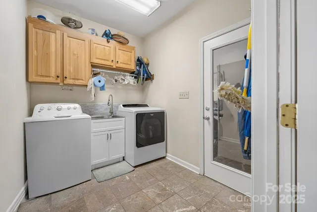 a utility room with cabinets washer and dryer