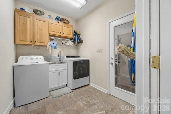 a utility room with cabinets washer and dryer