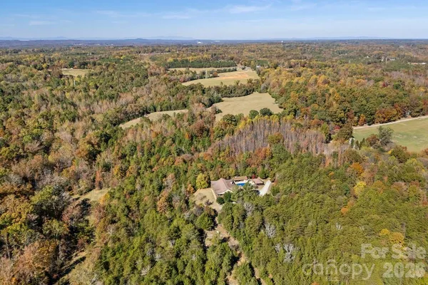 an aerial view of residential houses with outdoor space and trees