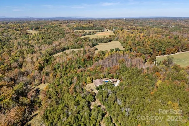 an aerial view of residential houses with outdoor space and trees