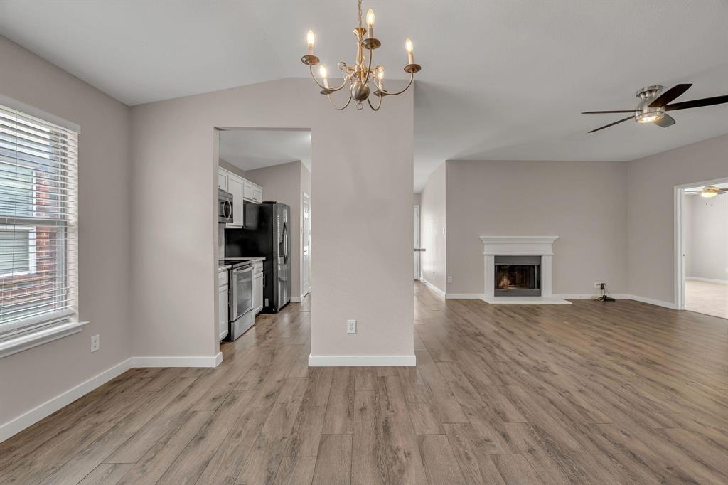 3920 Cane River Road Fort Worth, TX 76244 - Photo 21 of 22 an empty room with wooden floor fireplace and windows